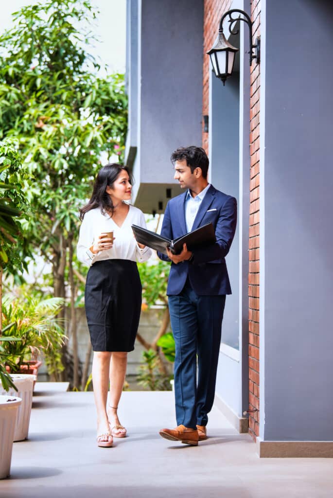 indian walking together discussing business project with file and coffee in modern office porch indian walking together discussing business project with file and coffee in modern office porch